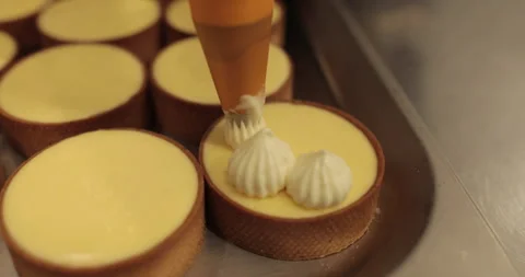 Decorating tartlets with cream using a culinary syringe. Stock Footage 255933598