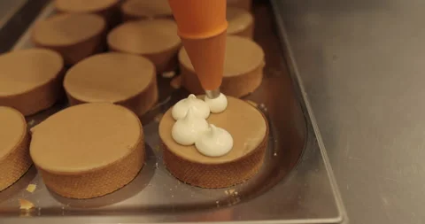 Decorating tartlets with cream using a culinary syringe. Stock Footage 255934450