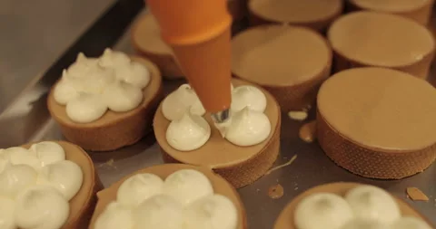 Decorating tartlets with cream using a culinary syringe. Stock Footage 255937198