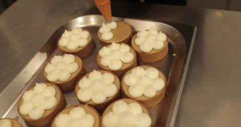 Decorating tartlets with cream using a culinary syringe. Stock Footage 255940488
