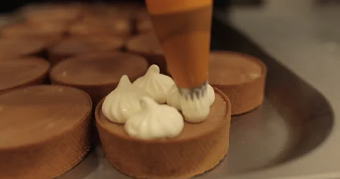 Decorating tartlets with cream using a culinary syringe. Stock Footage 255941570