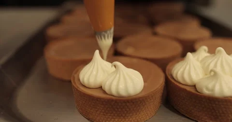 Decorating tartlets with cream using a culinary syringe. Stock Footage 255942494