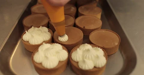 Decorating tartlets with cream using a culinary syringe. Stock Footage 255943618