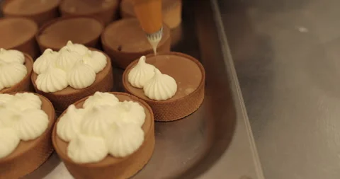 Decorating tartlets with cream using a culinary syringe. Stock Footage 255943927