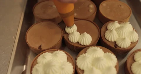 Decorating tartlets with cream using a culinary syringe. Stock Footage 255945174