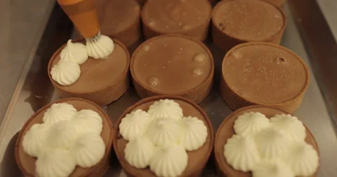 Decorating tartlets with cream using a culinary syringe. Stock Footage 255945587
