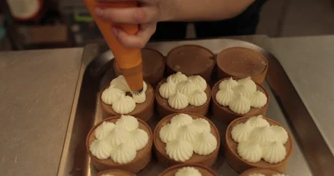 Decorating tartlets with cream using a culinary syringe. Stock Footage 255946787