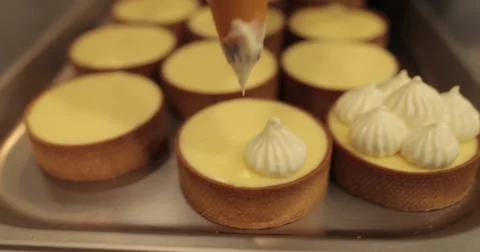 Decorating tartlets with cream using a culinary syringe. Professional confe.. Stock Photos