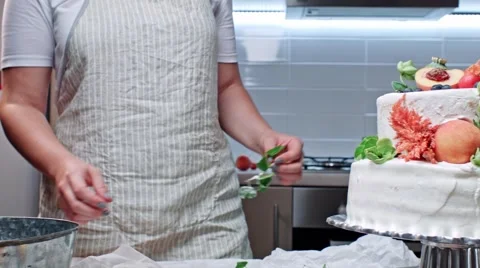 Decorating tier cake with fresh green, peach and cherry Stock Footage