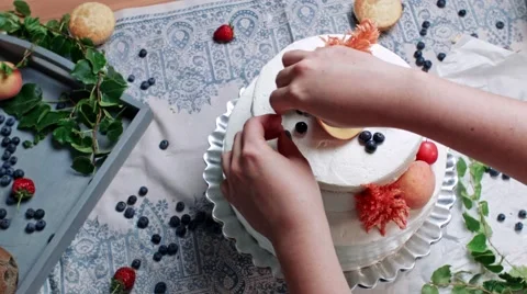 Decorating tier cake with fresh green, peach, cherry and blueberry Stock Footage 68019908