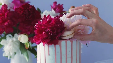 Decorating top of delicious wedding cake with peon buds and macaroons cakes. Stock Footage 105448167