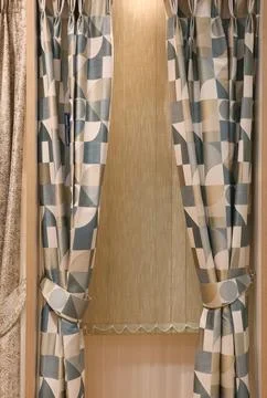 Decorating a window with geometric pattern drapes and a pleated blind for m.. Stock Photos