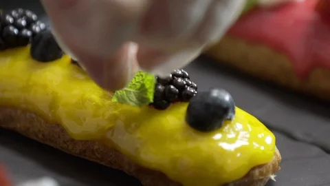 Decorating yellow glaze eclair with mint Stock Footage 95931131
