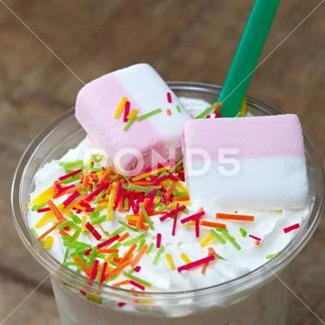 Decoration of a milkshake with confectionery. Cold sweet dessert. Stock Photos