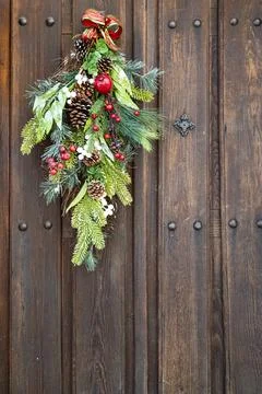 Decoration with pine branches and pine cones on a wooden door. Stock Photos