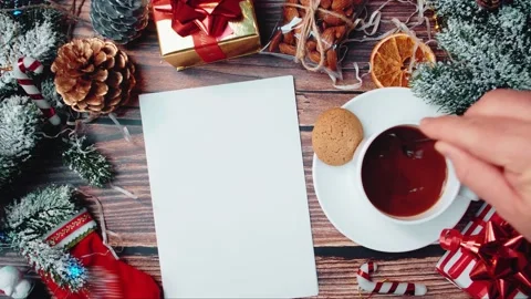 Decorations and hand putting a blank sheet of paper on the table stirring a mug Stock Footage 144957529