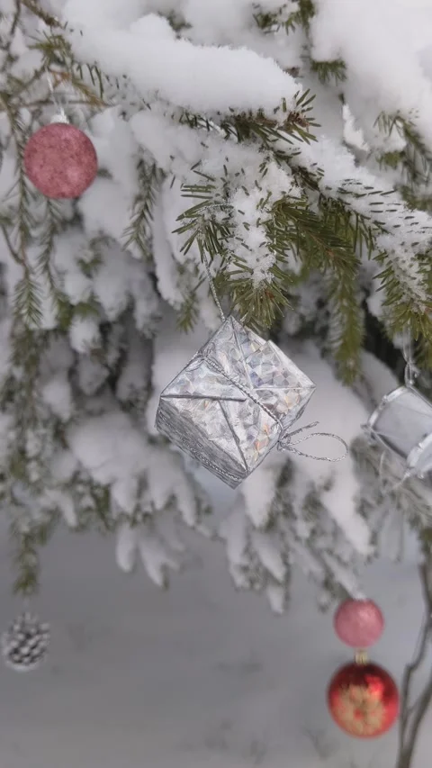Decorations on a Christmas tree in the forest. Gift box, drum, balls, snow Stock Footage 165777531