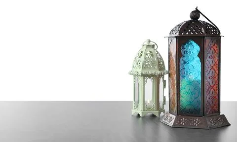 Decorative Arabic lanterns on grey table against white background Stock Photos