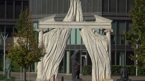 A decorative arch in front of multiple office buildings Stock Footage 134067344