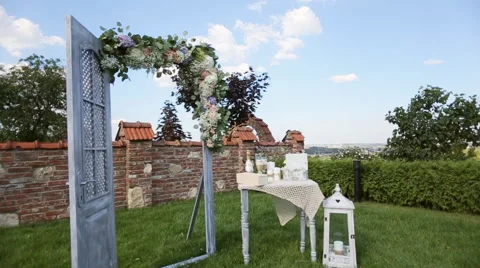 Decorative arch, table and lamp with flowers at a wedding ceremony outdoors Stock Footage 65955935