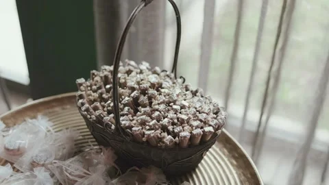 Decorative basket filled with wrapped wedding favors on golden tray Vidéo 337780831