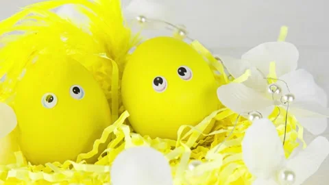 Decorative basket with yellow eggs decorated with feathers in the sun Stock Footage 174709161