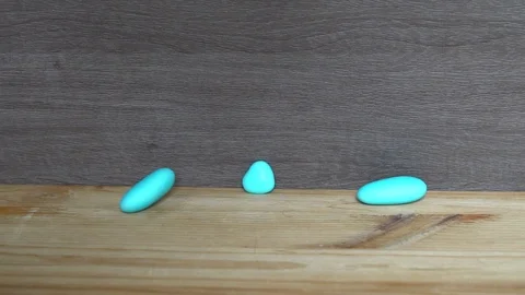 Decorative blue stone fall down on the wooden table Video stock 92678481