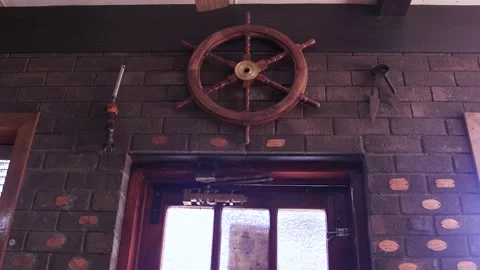 Decorative Boat Wheel Mounted Above Rustic Brick Doorway Vidéo 340497714
