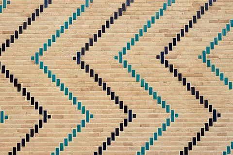 Decorative brickwork with turquoise and dark blue glazed tiles forming geom.. Stock Photos