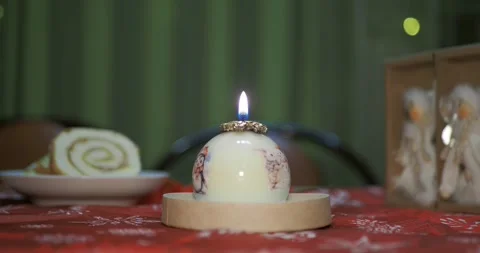 A decorative candle in the form of a ball with painted Christmas pictures. Vídeos de archivo 297612876