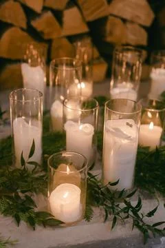 Decorative candles surrounded by greenery create a serene ambiance in a cozy Stock Photos
