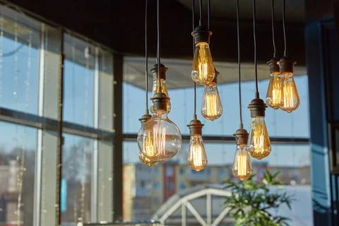 Decorative ceiling light bulbs shine with a dim light. Home decoration and Stock Photos