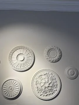 Decorative ceiling rosettes on plain wall creating an elegant interior back.. Stock Photos