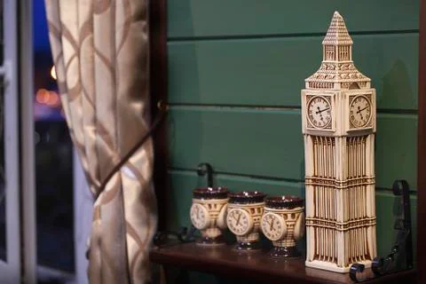 Decorative ceramic clock tower and cups in the interior of pub Stock Photos
