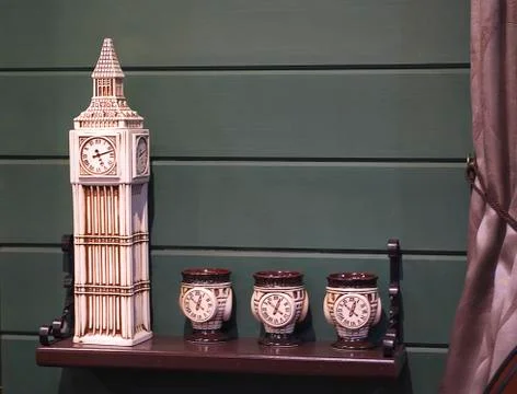 Decorative ceramic clock tower and cups in the interior of pub Stock Photos