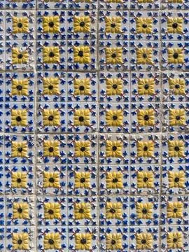 Decorative ceramic tiles with repeating yellow flowers and blue scrollwork .. Stock Photos