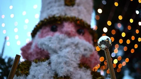 Decorative Christmas nutcracker soldier figure displayed outdoors with trees in Stock Footage 325800637