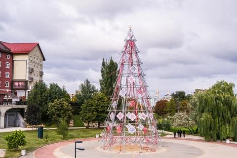 Decorative Christmas tree frame with patterns and ribbons in a park. Festive Stock Photos