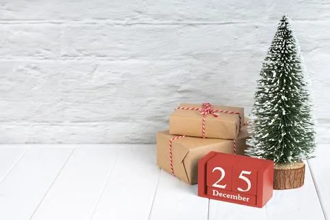 Decorative Christmas tree, gift boxes with in craft paper and red wooden perp Stock Photos