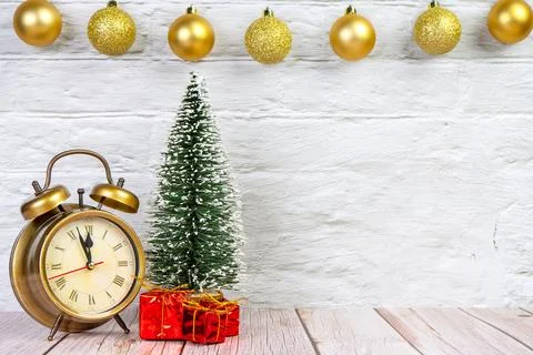 Decorative Christmas tree, gift boxes and bronze alarm clock on white backgro Stock Photos