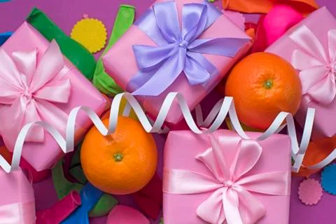 Decorative composition Three boxes with gifts Satin ribbon Bow Oranges Confet Stock Photos