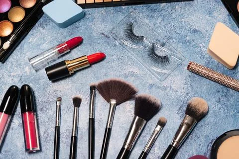 Decorative cosmetics, makeup brushes false eyelashes on a blue background. the Stock Photos