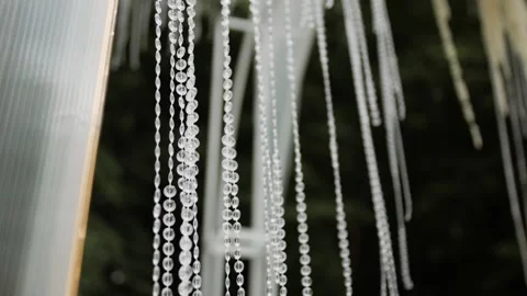 Decorative crystal strands hanging elegantly at a wedding ceremony venue Видео 338070352