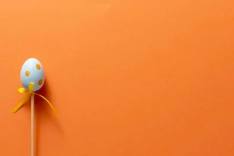 Decorative decoration in the form of Easter eggs on an orange background. Cop Stock Photos