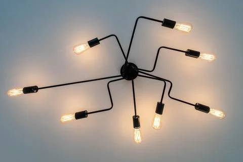Decorative designer lighting has been installed and glows bright hanging abov Stock Photos