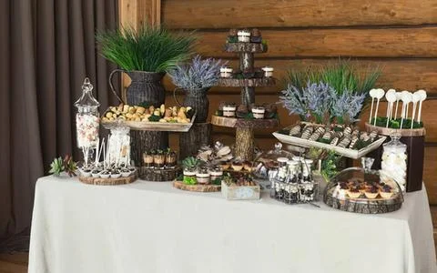 Decorative dessert table with sweets and plants in rustic style Stock Photos