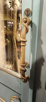 Decorative door handle in the shape of a snake in yellow color Stock Photos