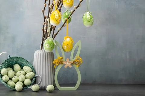 Decorative Easter arrangement with colored eggs, vase, and spring elements .. Stock Photos