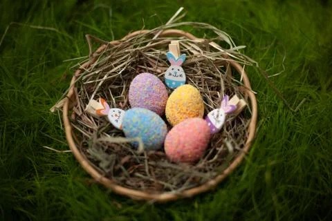 Decorative Easter colored eggs in a basket with hay decorated with Easter rab Foto stock