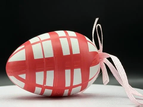 Decorative Easter egg with a red geometric grid pattern on a white background Stock Photos